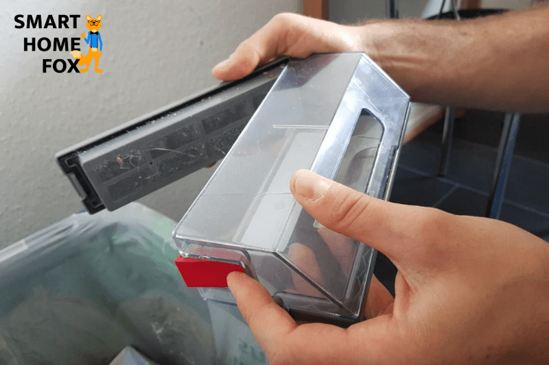 Emptying the mobile dust bag by hand over the dustbin.